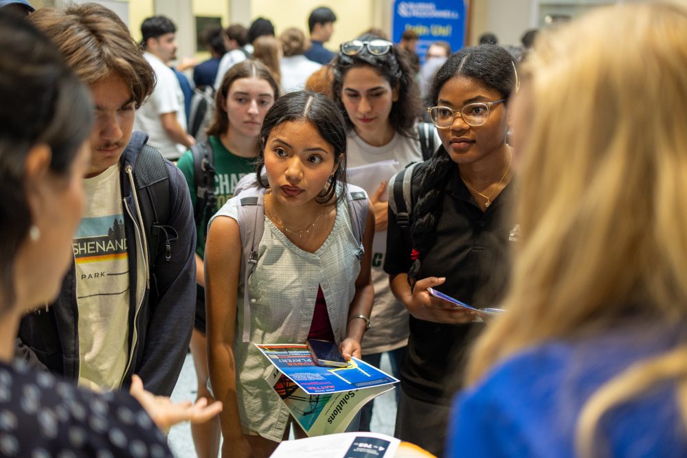 students at career fair talking to company representative 